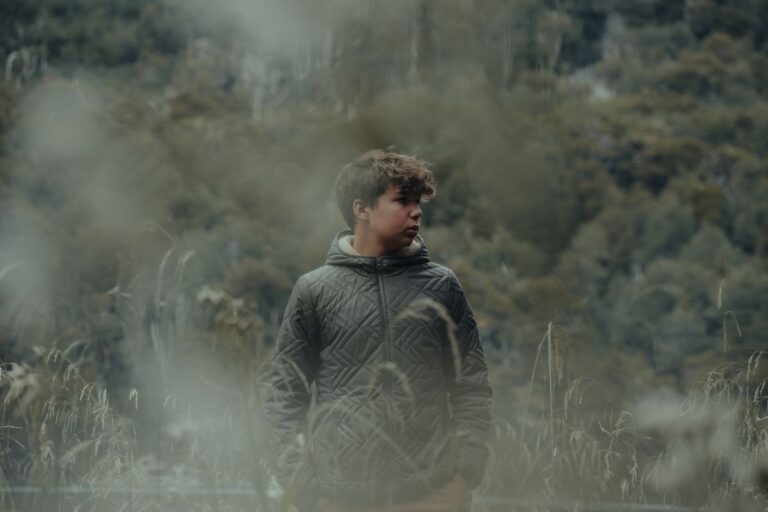 Man in gray puffer jacket looking afar.